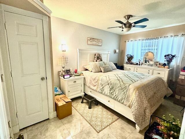 bedroom featuring ceiling fan and a textured ceiling