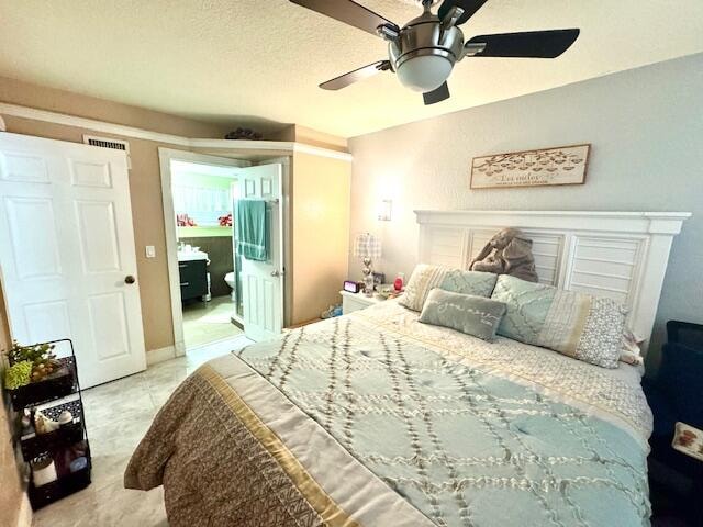 bedroom with a textured ceiling and ceiling fan