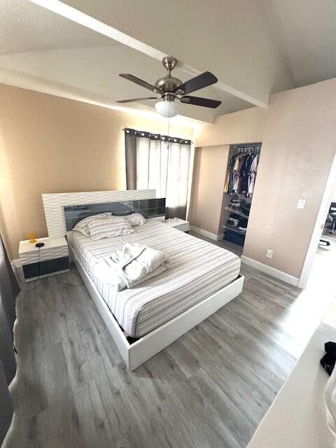 bedroom with hardwood / wood-style flooring, ceiling fan, vaulted ceiling, and a closet