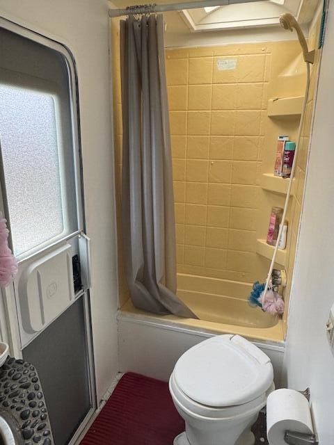 bathroom featuring toilet and shower / tub combo