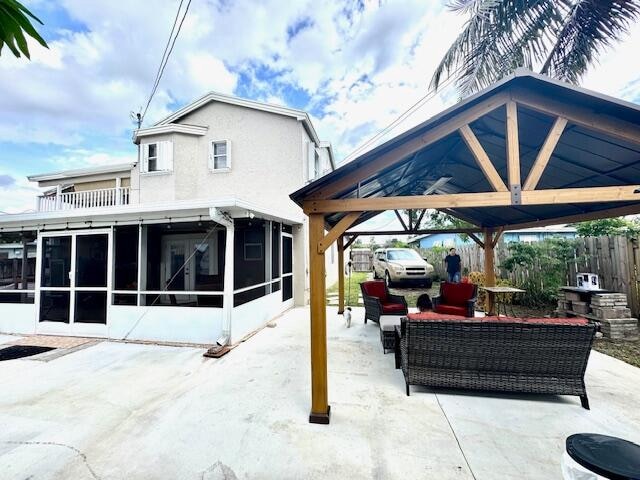 view of patio / terrace featuring an outdoor living space, a sunroom, and a gazebo