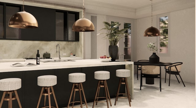 kitchen with a kitchen breakfast bar, sink, decorative light fixtures, and decorative backsplash