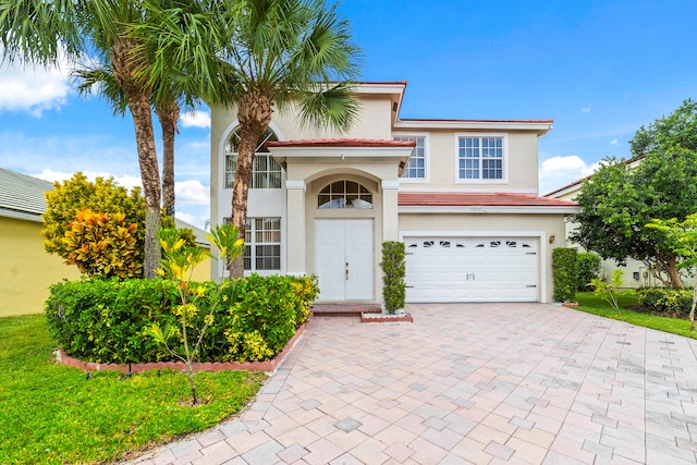 mediterranean / spanish-style home featuring a garage and a front lawn