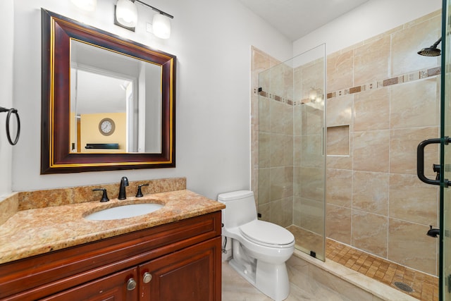 bathroom with walk in shower, vanity, and toilet