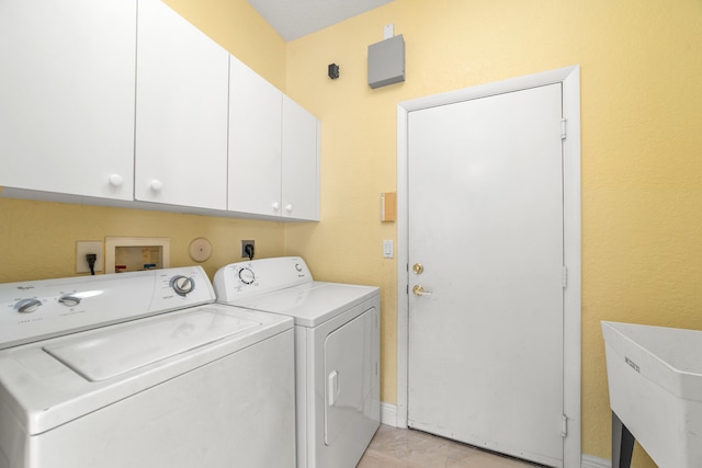 washroom with sink, cabinets, and independent washer and dryer