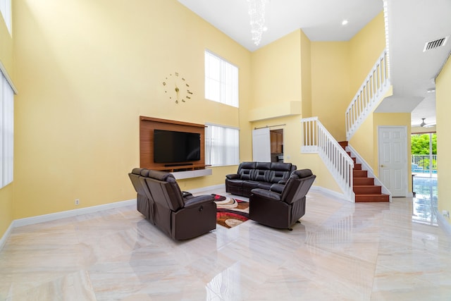 living room featuring an inviting chandelier and a towering ceiling