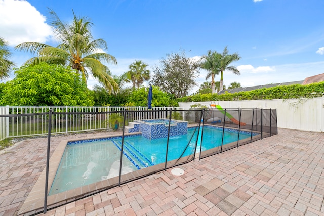 view of pool featuring a patio and an in ground hot tub