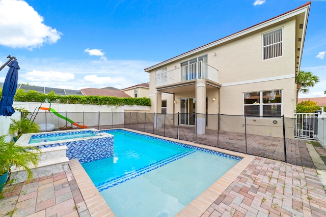 view of pool featuring a patio and an in ground hot tub