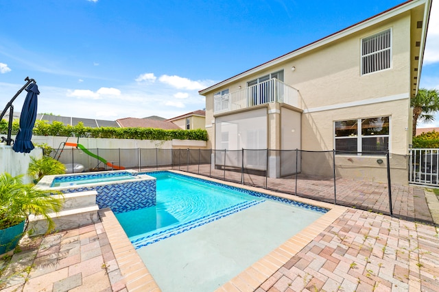 view of pool featuring a patio area and an in ground hot tub