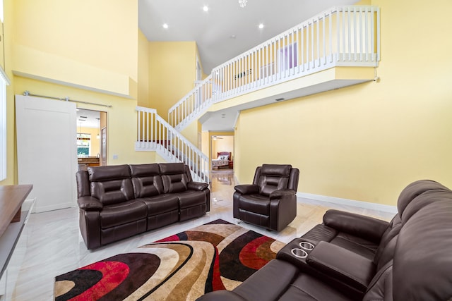 living room with a barn door and a high ceiling