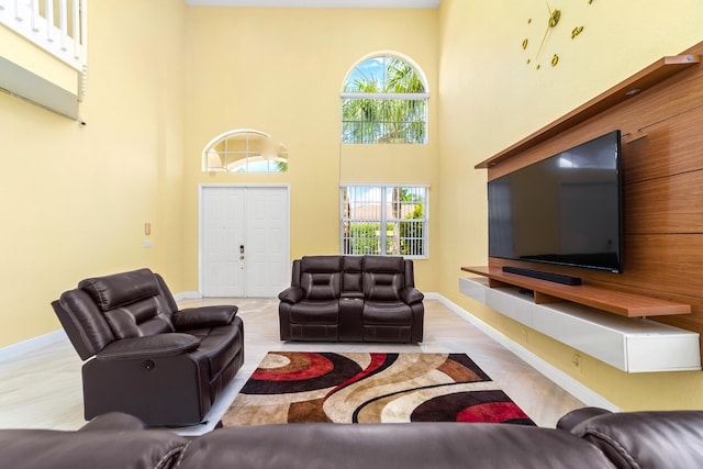 living room with light hardwood / wood-style floors and a high ceiling