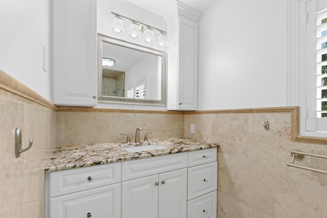 bathroom with plenty of natural light, vanity, and tile walls