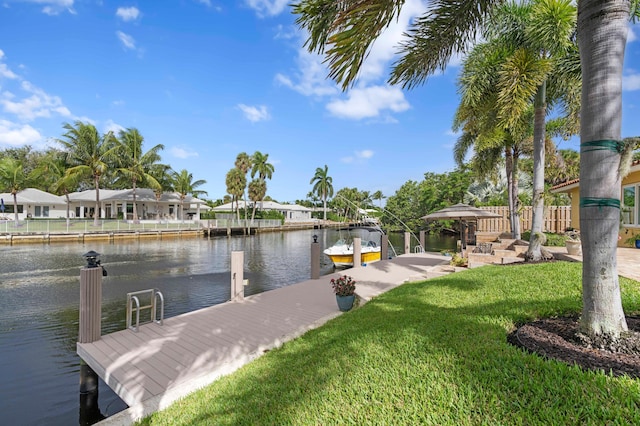 view of dock with a yard and a water view