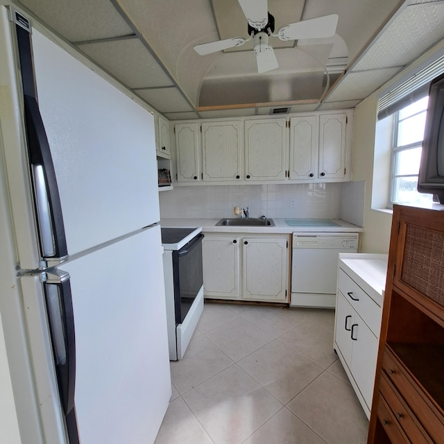 kitchen featuring light tile patterned flooring, sink, white cabinetry, white appliances, and backsplash