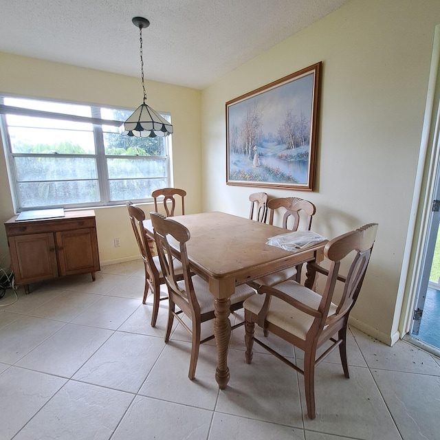 tiled dining space with a textured ceiling