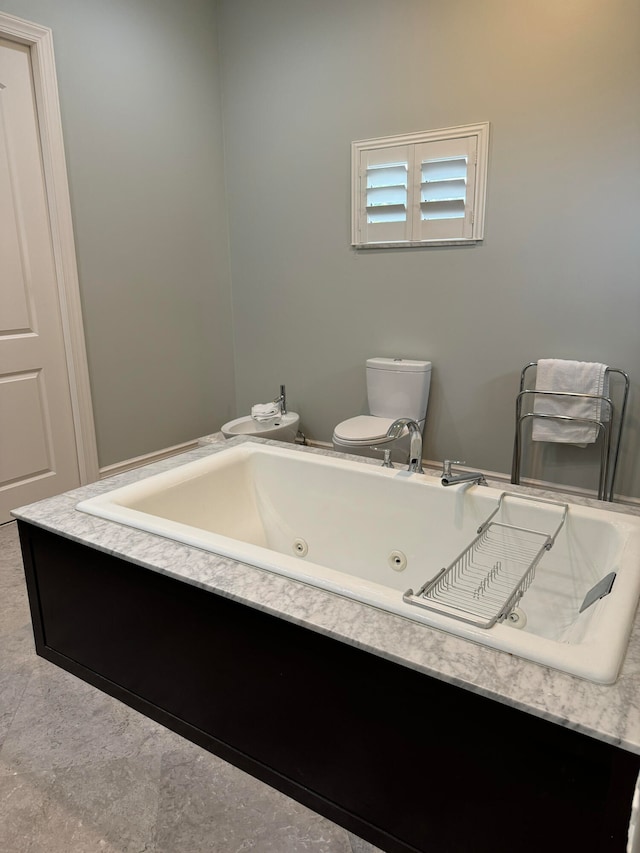 bathroom featuring a tub, tile patterned floors, and toilet