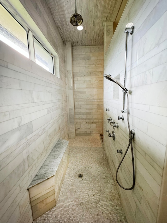 bathroom with wooden walls and a tile shower