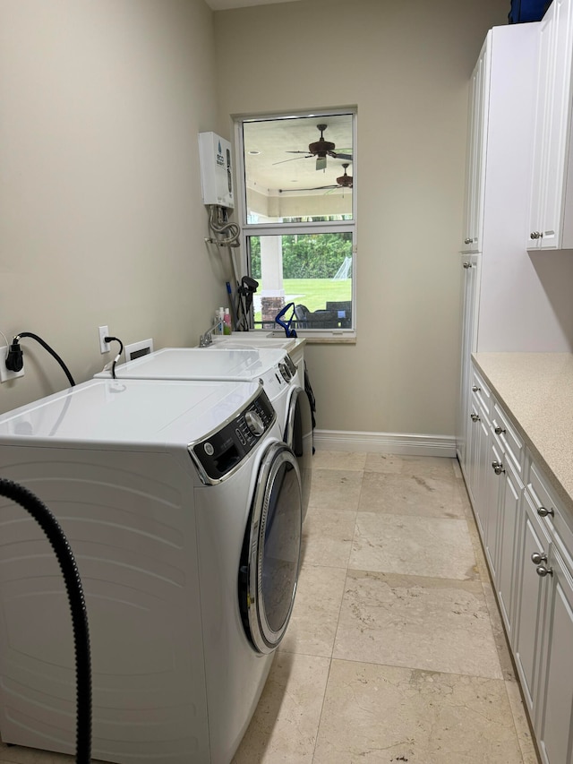 washroom featuring cabinets, ceiling fan, water heater, and washer and clothes dryer