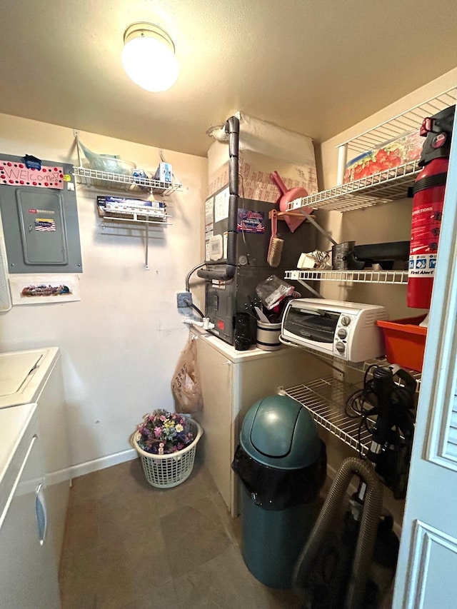 utility room featuring electric panel and washer and clothes dryer