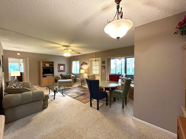 carpeted dining space featuring ceiling fan, a healthy amount of sunlight, and a textured ceiling