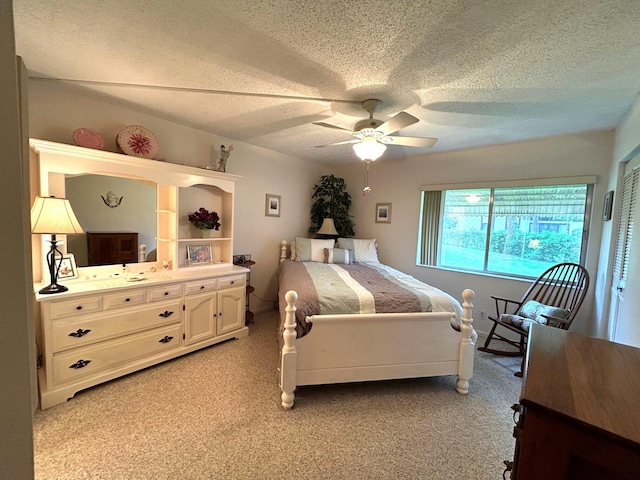 bedroom with a textured ceiling, light carpet, and ceiling fan