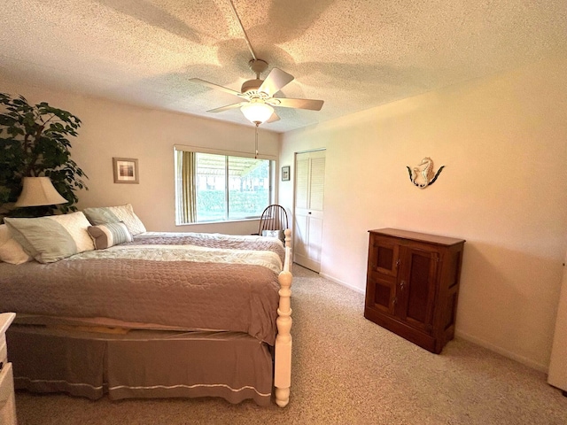 carpeted bedroom with a textured ceiling, ceiling fan, and a closet