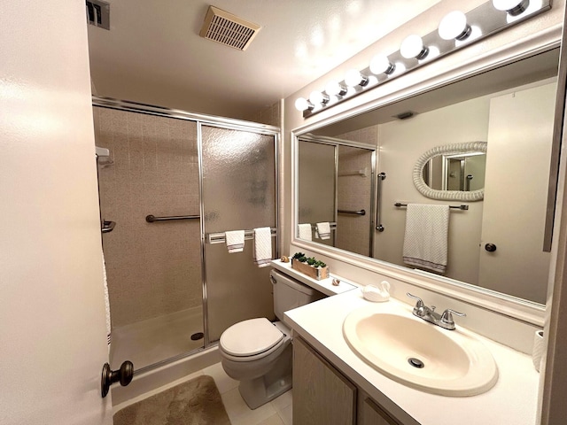 bathroom featuring toilet, vanity, tile patterned floors, and a shower with shower door