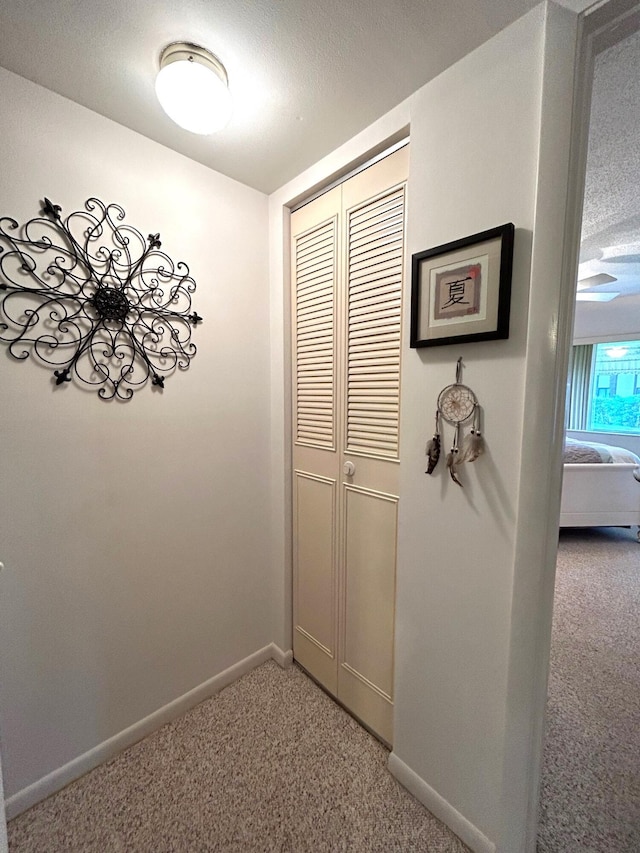 corridor featuring carpet and a textured ceiling