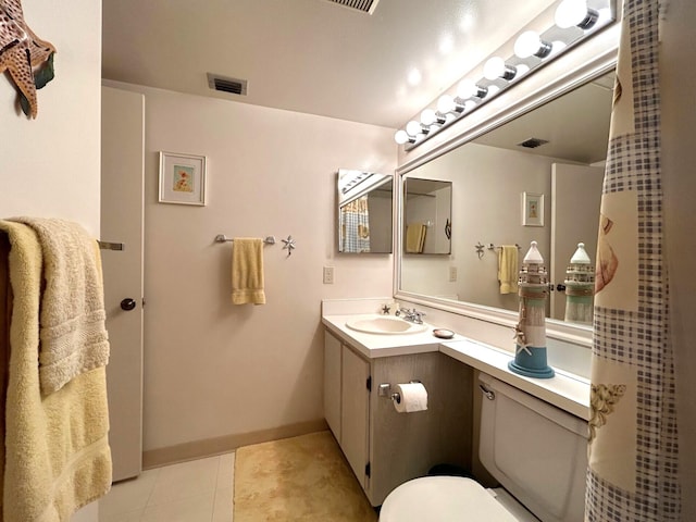 bathroom featuring tile patterned flooring, vanity, and toilet