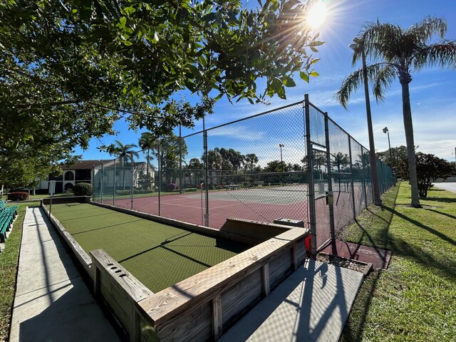 view of sport court featuring a lawn