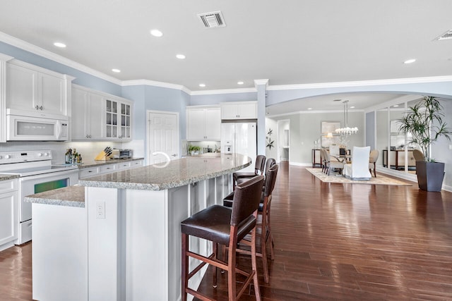 kitchen featuring white appliances, dark hardwood / wood-style floors, and a center island