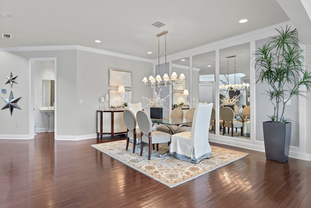 dining area featuring ornamental molding, dark wood-type flooring, sink, and a notable chandelier