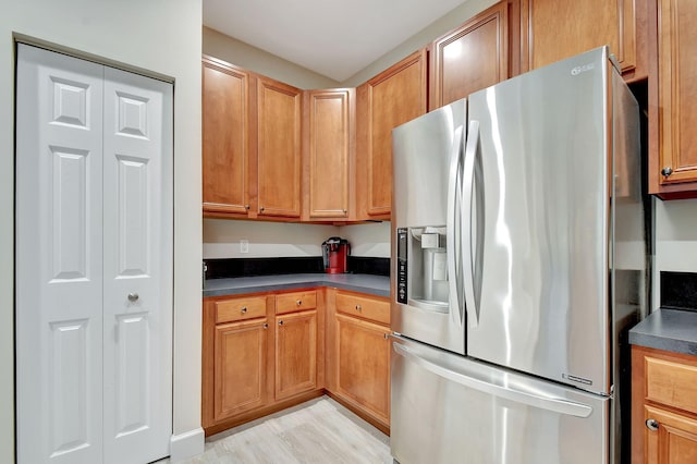 kitchen with stainless steel refrigerator with ice dispenser and light hardwood / wood-style floors