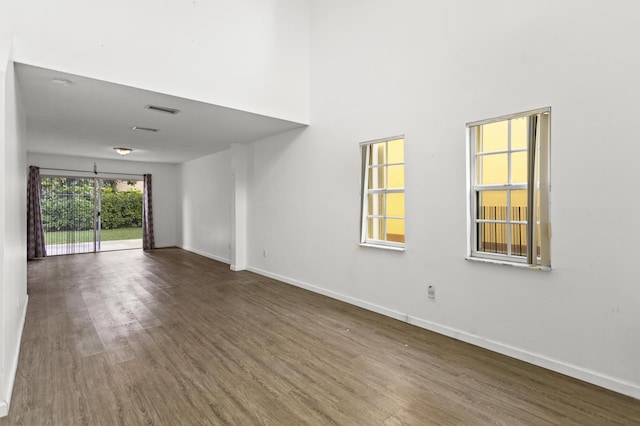 spare room featuring dark wood-type flooring and a high ceiling