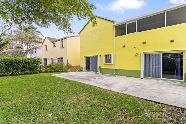 rear view of house with a patio area and a lawn