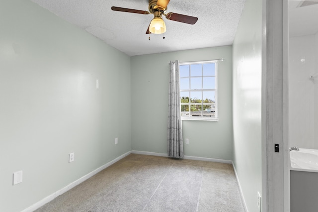 unfurnished room featuring ceiling fan, carpet floors, and a textured ceiling