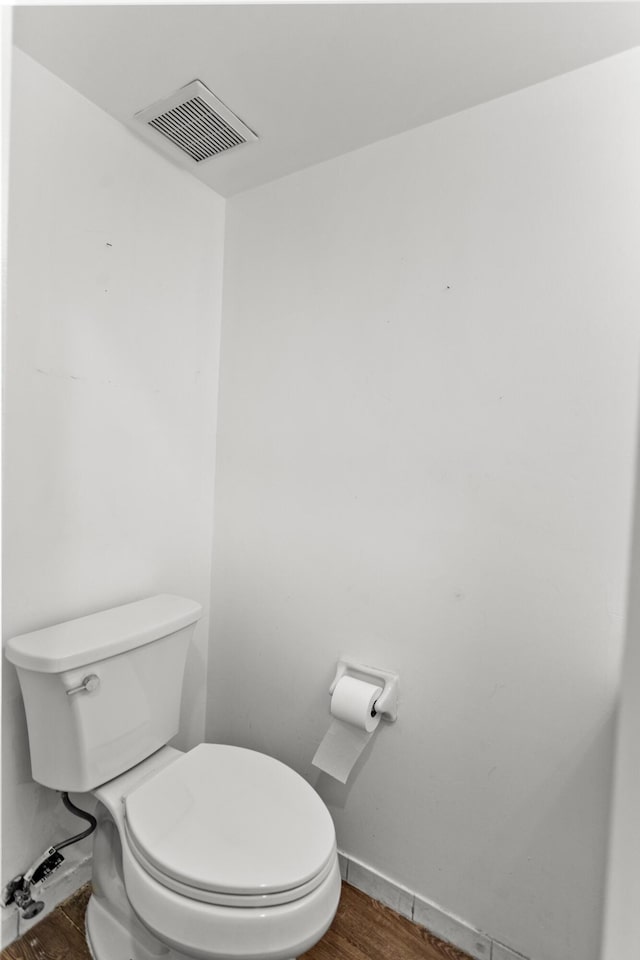 bathroom with hardwood / wood-style floors and toilet