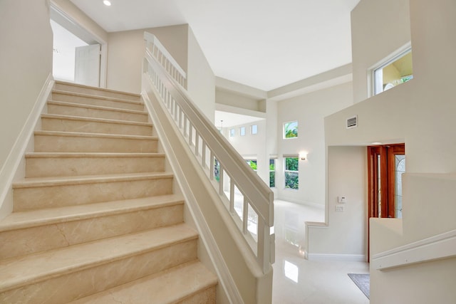 staircase with a towering ceiling