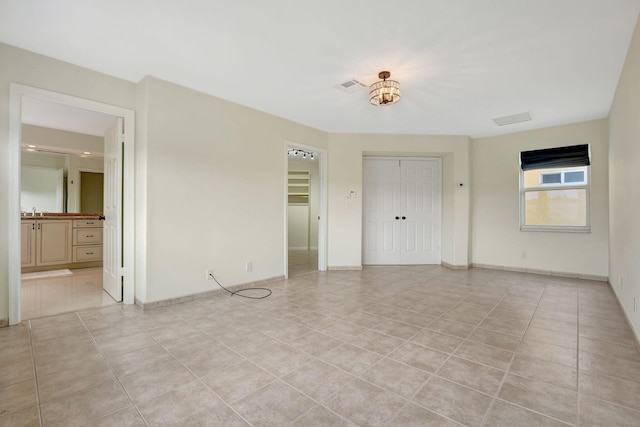 unfurnished room with light tile patterned flooring and sink