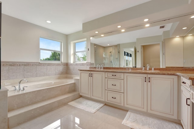 bathroom with tile patterned flooring, vanity, and plus walk in shower