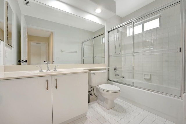 full bathroom featuring tile patterned flooring, shower / bath combination with glass door, vanity, and toilet