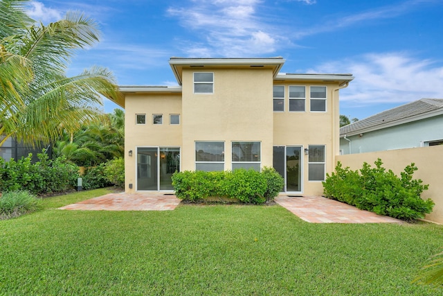 back of property featuring a patio and a lawn