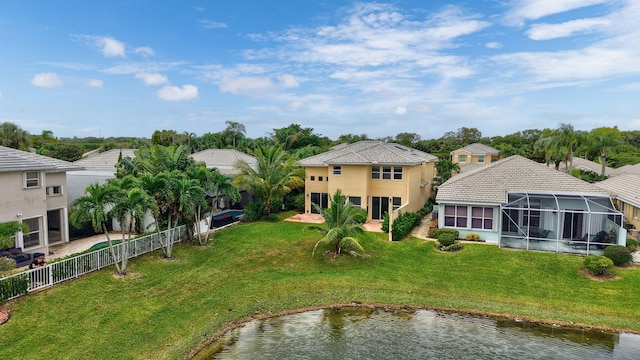 exterior space with a lanai, a water view, and a lawn