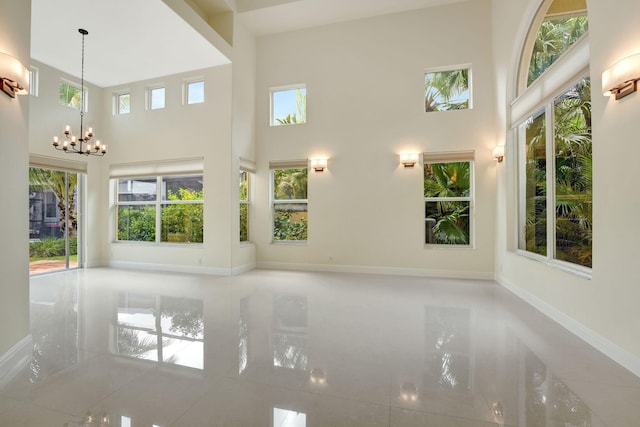 unfurnished living room with a notable chandelier and a high ceiling