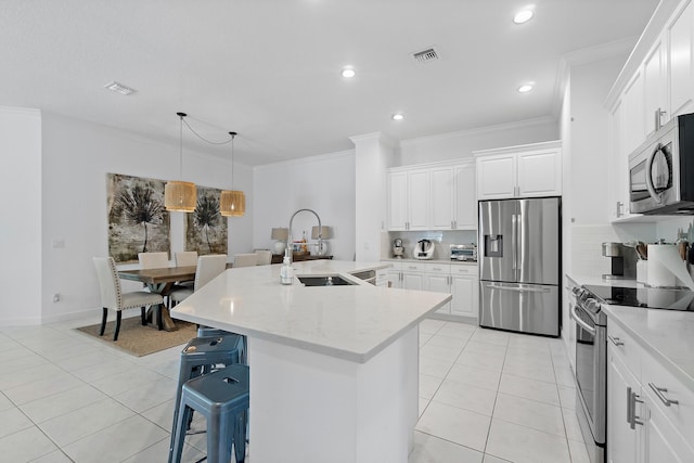 kitchen featuring stainless steel appliances, white cabinetry, light stone countertops, sink, and a kitchen island with sink