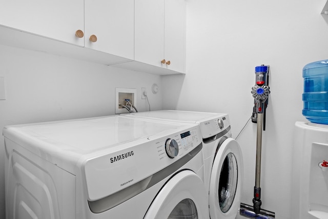 laundry room featuring cabinets and washer and clothes dryer