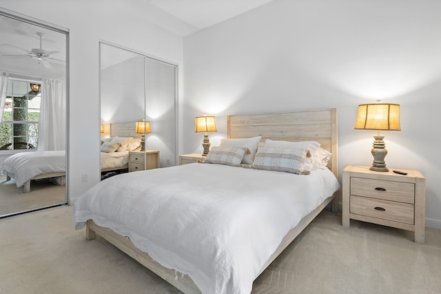 bedroom featuring multiple closets, light colored carpet, and ceiling fan