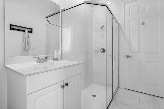 bathroom with walk in shower, vanity, and tile patterned floors