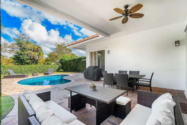 view of swimming pool featuring a grill, outdoor lounge area, ceiling fan, and a patio area