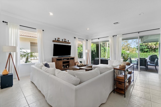 living room with ornamental molding and light tile patterned floors